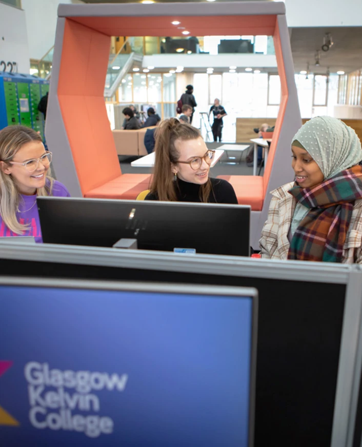 Three students using desktop computers and working together in the Springburn campus library at Glasgow Kelvin College Three students using desktop computers and working together in the Springburn campus library at Glasgow Kelvin College